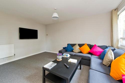 a living room with a blue couch with colorful pillows at ALTIDO Spacious apt with private yard in Notting Hill in London