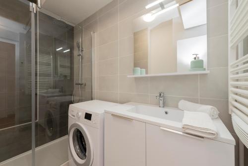 une salle de bain avec une machine à laver et un lavabo dans l'établissement Le St Honoré - 7ème étage avec vue sur la ville, à Toulouse