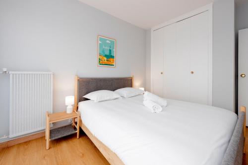 une chambre avec un grand lit blanc et une table dans l'établissement Le St Honoré - 7ème étage avec vue sur la ville, à Toulouse