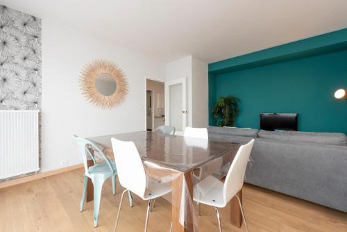 une salle à manger avec une table en verre et des chaises blanches dans l'établissement Le St Honoré - 7ème étage avec vue sur la ville, à Toulouse