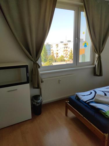 a bedroom with a bed and a large window at Apartmán blízko centra Levice in Levice