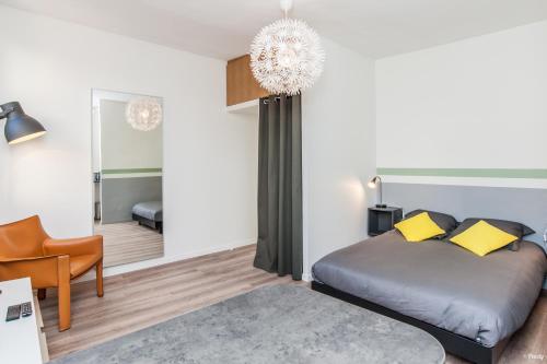 a bedroom with a bed and a chair and a mirror at Le Casanova - Proche du métro Compans-Caffarelli in Toulouse