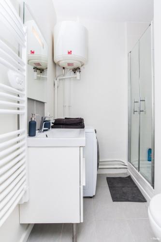 une salle de bain blanche avec un lavabo et des toilettes dans l'établissement Le Casanova - Proche du métro Compans-Caffarelli, à Toulouse