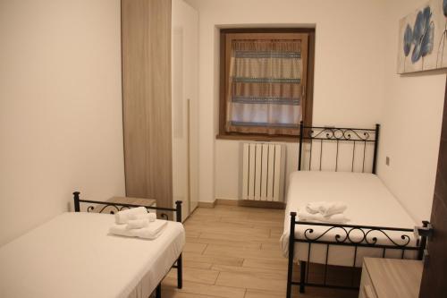 two beds in a small room with a window at Villa TaDi LaRo Luxury Deluxe Comer See Colico in Colico