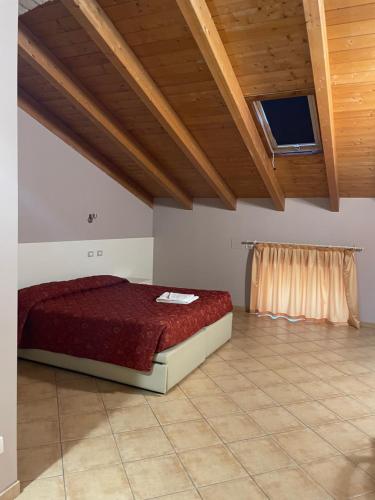 una camera con un letto in una stanza con soffitto in legno di Hotel La Cascina a Fontanellato