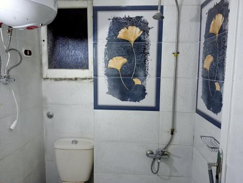 uma casa de banho com WC e uma fotografia na parede em فيروزة ميامي إطلالة على البحر عائلات فقط أو رجال فقط em Alexandria