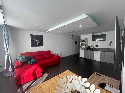 uma sala de estar com um sofá vermelho e uma cozinha em Bel appart stylé avec jacuzzi em Sedan