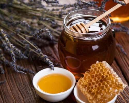 a jar of honey with a piece of honeycomb and a bowl of honey at Matamata Country B&B in Matamata