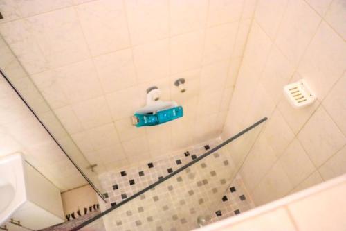 y baño con ducha con un objeto azul en la pared. en Yaxida's Warmth, en Kasane