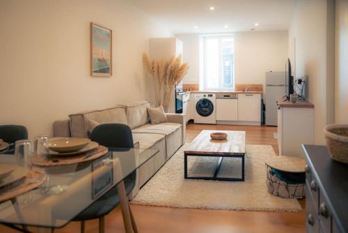 ein Wohnzimmer mit Sofa und Tisch in der Unterkunft SplendideT2 centre ville & terrasse extérieure in Cognac