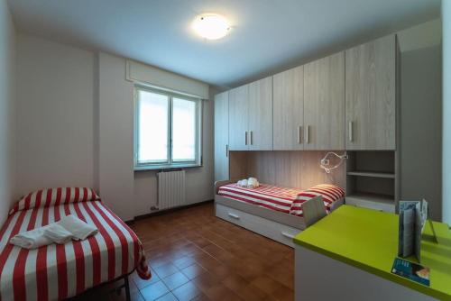 Habitación pequeña con 2 camas y escritorio verde. en Casa Magnodeno, en Lecco