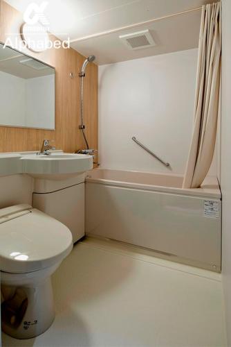 a bathroom with a toilet and a sink and a tub at ALPHABED INN Takamatsuekimae in Takamatsu