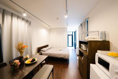 a small white room with a bed and a table at FL Residence Shinjuku Kawadacho in Tokyo