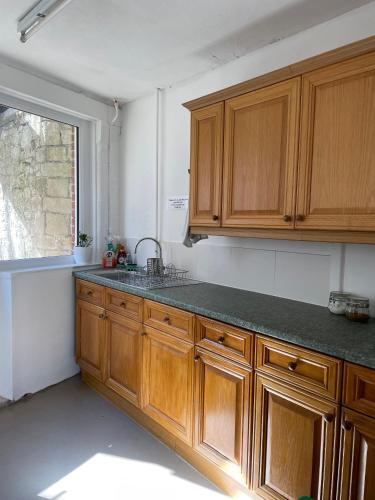 a kitchen with wooden cabinets and a sink and a window at Portland Outdoor Centre Hostel in Portland