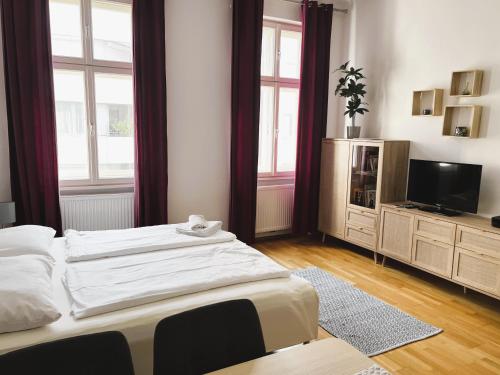 a bedroom with two beds and a flat screen tv at Casa Nostra - Helle Wohnung - direkt am Augarten in Vienna