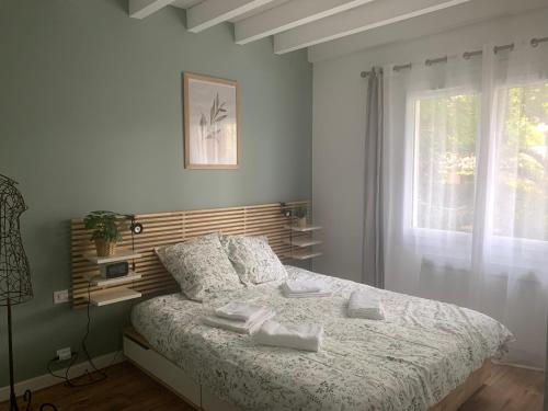 een slaapkamer met een bed en een raam bij Villa "OSTAU OCÉANE" in Capbreton