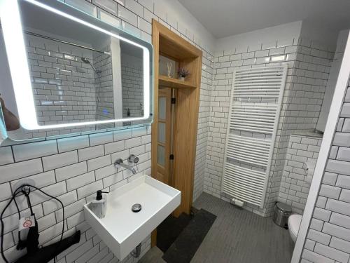 Baño blanco con lavabo y espejo en Apartament en Bruselas