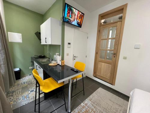 eine Küche mit einem Tisch und 2 gelben Stühlen in der Unterkunft Apartament in Brüssel