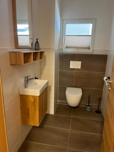 La salle de bains est pourvue de toilettes, d'un lavabo et d'une fenêtre. dans l'établissement Ferienwohnung mit wunderschöner Bergkulisse, à Matrei in Osttirol