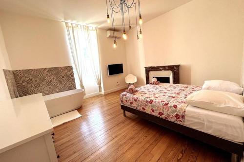 une chambre avec un lit et un lustre dans l'établissement Gaby - Du cachet pour toute la famille, à Avignon