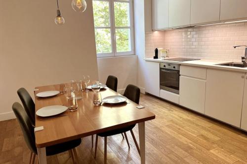 une table de salle à manger avec des chaises et une cuisine dans l'établissement Gaby - Du cachet pour toute la famille, à Avignon