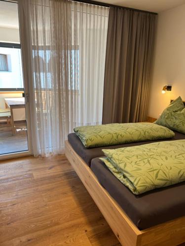 a bedroom with two beds and a door to a balcony at Ferienwohnung mit wunderschöner Bergkulisse in Matrei in Osttirol