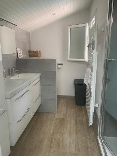 een witte badkamer met een wastafel en een raam bij Villa "OSTAU OCÉANE" in Capbreton