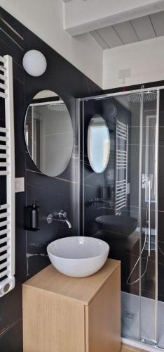 ein Bad mit einem Waschbecken und einem Spiegel in der Unterkunft Nodo in Civitanova Marche