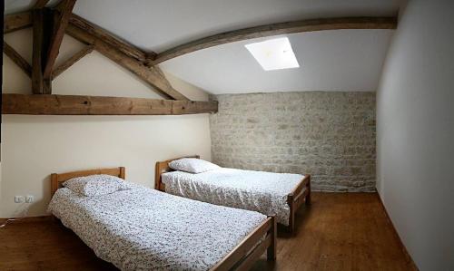 1 Schlafzimmer mit 2 Betten und Ziegelwand in der Unterkunft 8 Gite Complex, 53 People maximum , Marriage, Birthdays, family get togethers in Doeuil-sur-le-Mignon