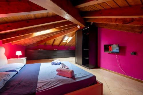 een slaapkamer met roze muren en een bed met een tv bij Leonardo Academy in 5' - MXP, Laghi e Wi-Fi in Sesto Calende