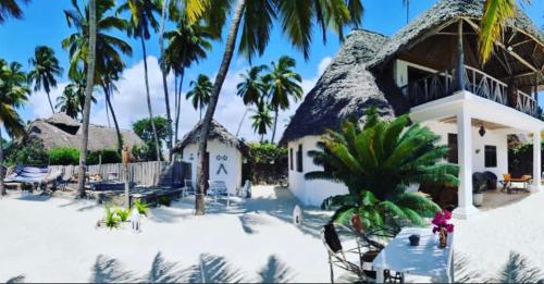 un complexe avec des palmiers et un bâtiment dans l'établissement The Loft Zanzibar Kikadini Beach, à Jambiani