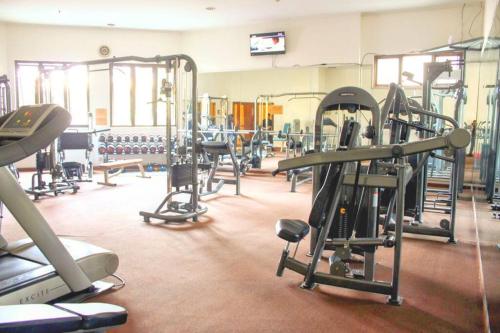 a gym with a lot of treadmills and machines at Cottonwood Midcentury Apartment at Majesty 811 in Bandung