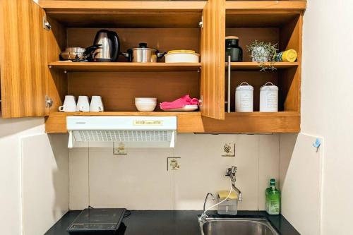 a kitchen with a sink and a counter top at Cottonwood Midcentury Apartment at Majesty 811 in Bandung