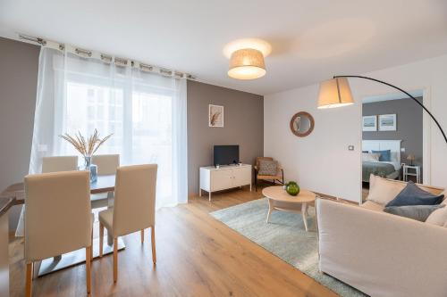 a living room with a table and a dining room at OVELIA Lyon - Les Jardins d'Hortense in Lyon