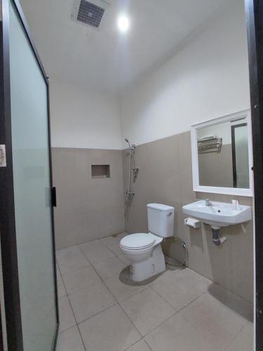 a bathroom with a toilet and a sink at Grand Tawiri Hotel 