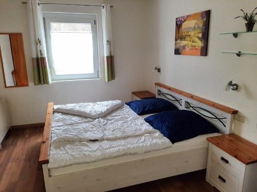 Schlafzimmer mit einem Bett, einem Fenster und einem Fenster in der Unterkunft Feriendorf Reichenbach - Dachspfad 7 in Nesselwang