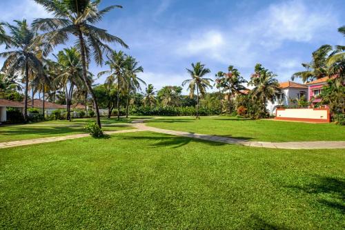a park with palm trees and a path at Radisson Blu Resort, Goa in Cavelossim