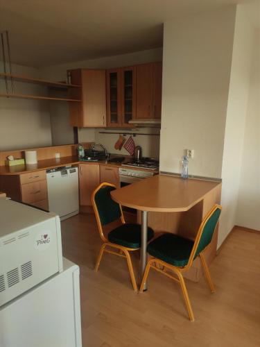 a kitchen with a wooden table and chairs in a room at Fast Apartment close by centrum in Levice
