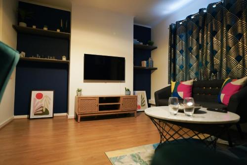 a living room with a couch and a table at Enfield North London 3BR Apartment in London