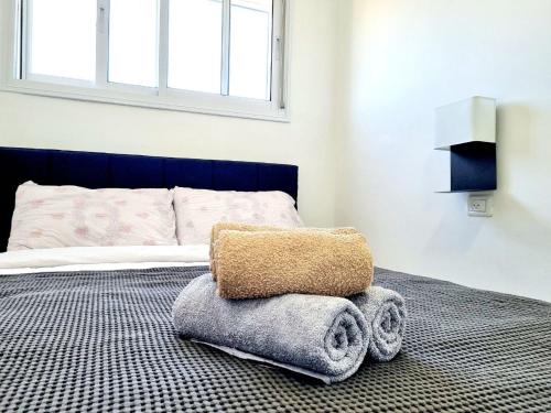 um quarto com uma cama com uma almofada e toalhas em "Robert Sold Zugit" from Shneider apartments em Qiryat Shemuʼel