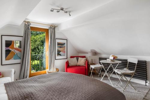 イブシャムにあるLittle Moat - Moat Farm Barns a small modern studio in the garden on our family farmのベッドとテーブルと椅子のある寝室