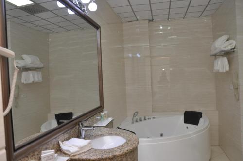 a bathroom with a tub and a sink at Addissinia Hotel in Addis Ababa