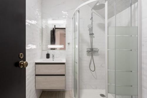 uma casa de banho com um chuveiro e uma porta de vidro em ALTIDO Superb studio with patio in Faro em Faro