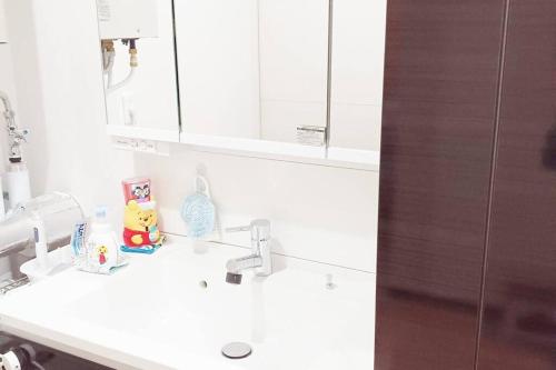 a white bathroom with a sink and a mirror at アンドステイ上士幌 in Kami-shihoro