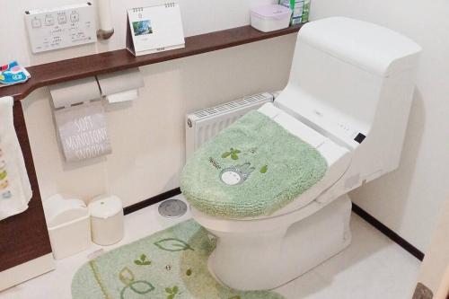 baño con aseo y toalla verde en アンドステイ上士幌, en Kami-shihoro