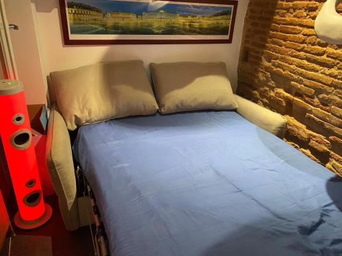 - un petit lit dans une chambre dotée d'un mur en briques dans l'établissement petit appartement cosy, à Toulouse