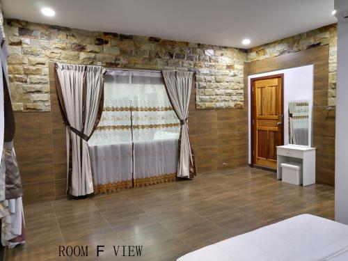 a bedroom with a bed and a stone wall at Mersing Maple Villa in Mersing