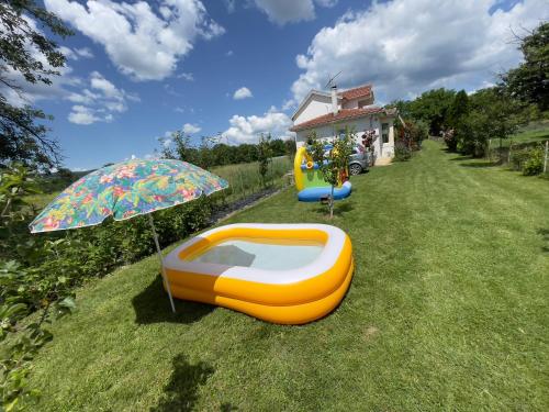 a backyard with a boat and an umbrella and a house at Vila Hristov in Delčevo