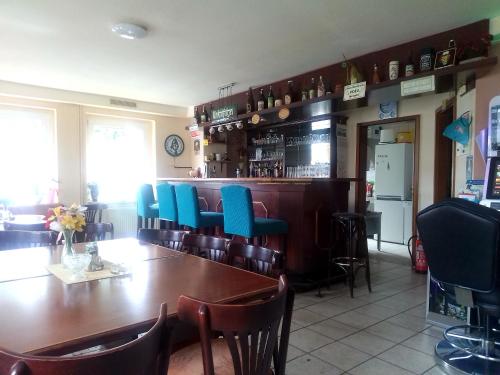a dining room with a wooden table and blue chairs at Pension Am Stadion in Kölleda