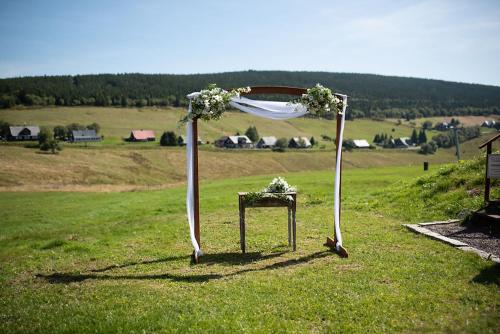 an arch with flowers and a table in a field at Wellness Resort Bouda Malá Úpa in Horní Malá Úpa
